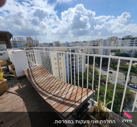 מעקה מתכת לבן על מרפסת עץ עם עציצים